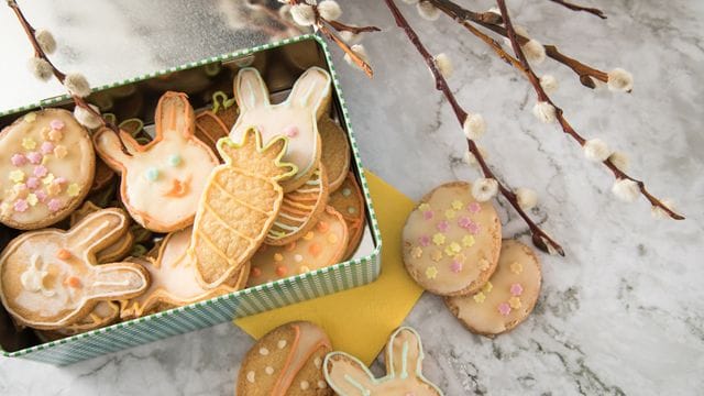 Putzige Zitronenplätzchen tummeln sich in einer Keksdose auf dem Ostertisch.