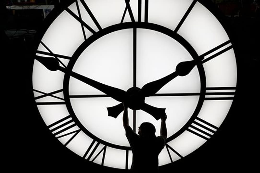 Zeitumstellung: Ein Techniker bewegt die Zeiger einer Uhr mit einem Durchmesser von mehr als 3,5 Metern. (Symbolbild)
