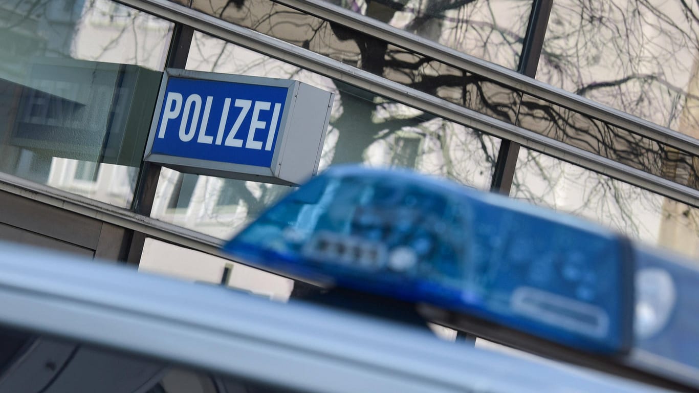 Ein Polizeiauto steht unter dem Schild an einer Wache (Symbolbild): Nachdem er gewalttätig gegenüber seiner Frau geworden ist, wurde ein Mann in Polizeigewahrsam genommen.