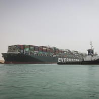 Ein Schlepperboot beteiligt sich an der Freisetzung eines im Suezkanal gestrandeten Containerschiffs.