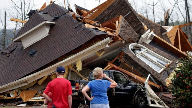 Anwohner begutachten die Schäden an ihren Häusern, nachdem ein Tornado südlich von Birmingham mehrere Häuser beschädigt hat. Anwohner begutachten die Schäden an ihren Häusern, nachdem ein Tornado südlich von Birmingham mehrere Häuser beschädigt hat.