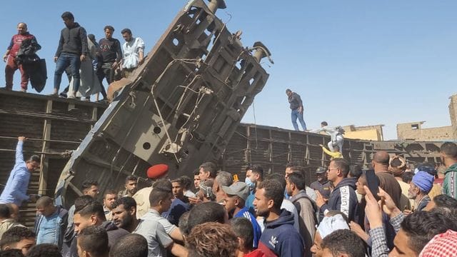 Menschen versammeln sich nach dem Zusammenstoß der Züge an den beschädigten Waggons. Menschen versammeln sich nach dem Zusammenstoß der Züge an den beschädigten Waggons.