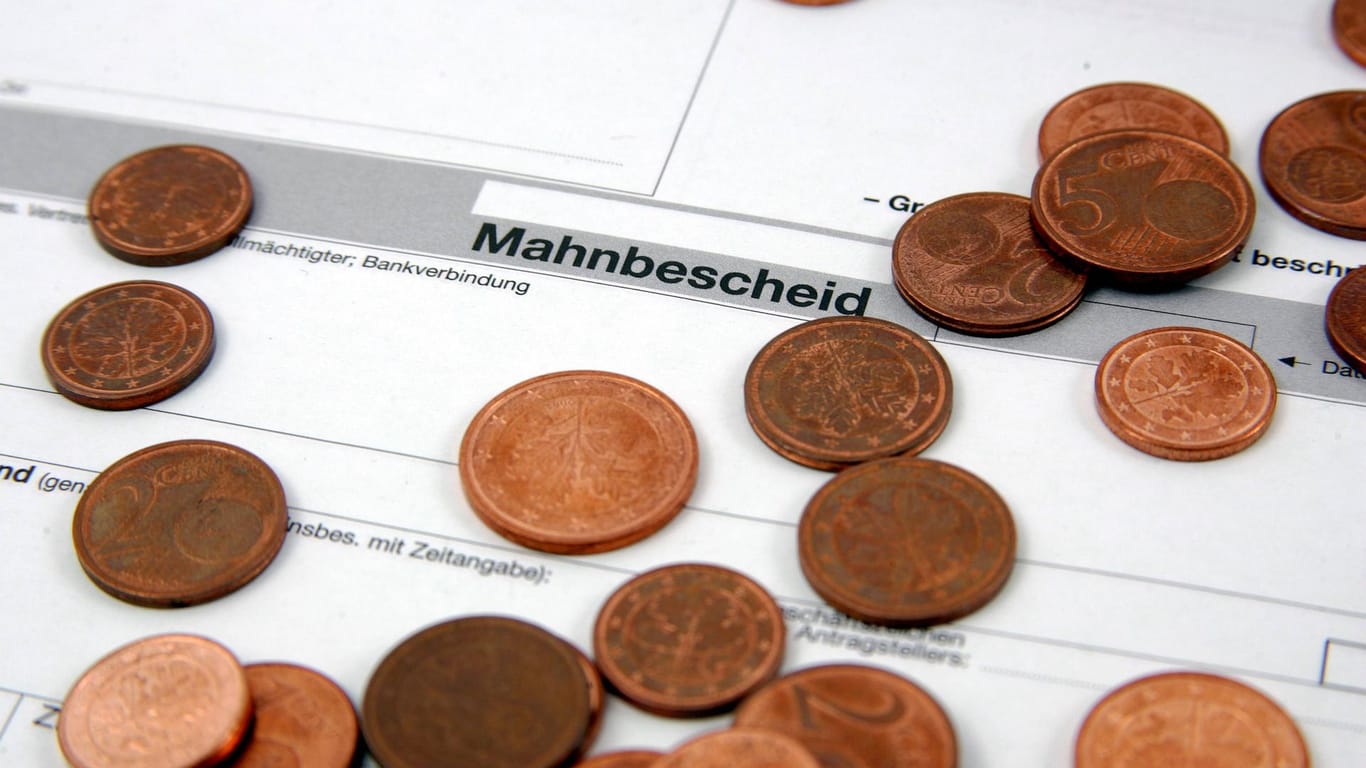 Centstücke liegen auf einem Mahnbescheid (Symybolbild): Die Agentur für Arbeit fordete einen Cent von der Düsseldorferin.