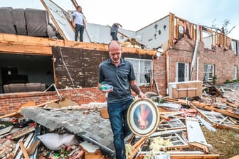Ein Mann holt persönliche Gegenstände aus einem zerstörten Haus: Im Süden des Landes hat eine Reihe von Tornados eine Schneise der Verwüstung hinterlassen.