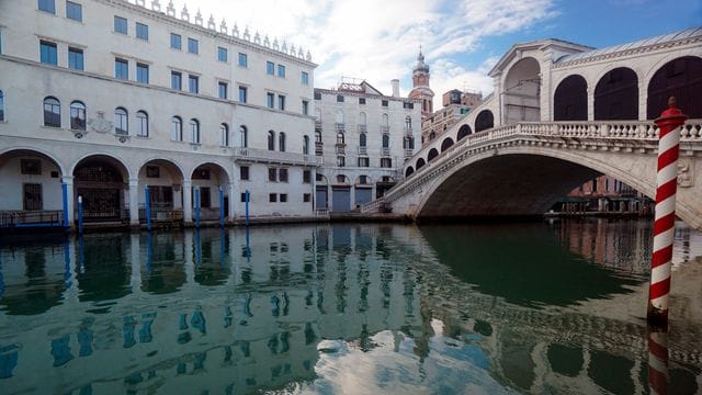 Die menschenleere Rialtobrücke spiegelt sich im Canal Grande. Die menschenleere Rialtobrücke spiegelt sich im Canal Grande.