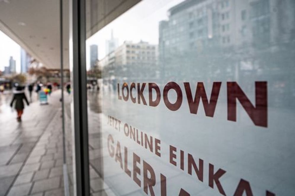 "Lockdown" steht im Schaufenster eines geschlossenen Kaufhauses, das darunter zum Online-Einkauf rät.