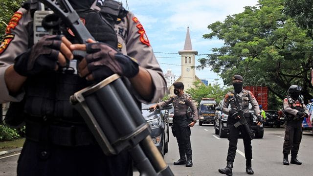 Bewaffnete Polizisten sichern die Umgebung ab.