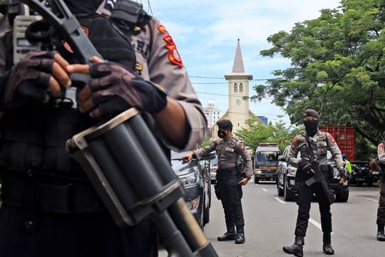 Bewaffnete Polizisten sichern die Umgebung ab.