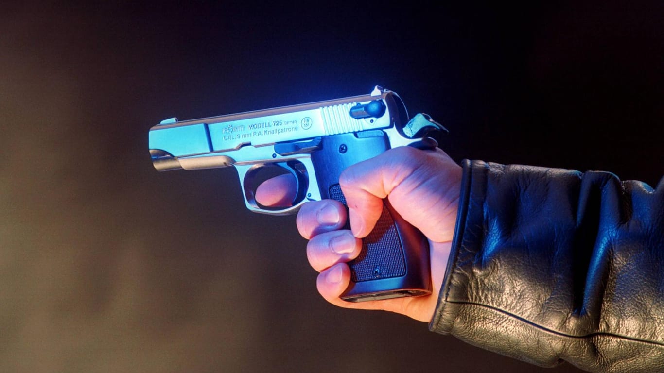 Eine Person hält eine Waffe in der Hand (Symbolbild): In einem Regionalzug in Hessen hat ein Mann einen Schuss abgegeben.