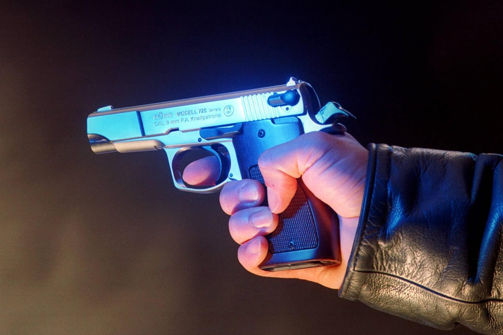 Eine Person hält eine Waffe in der Hand (Symbolbild): In einem Regionalzug in Hessen hat ein Mann einen Schuss abgegeben.