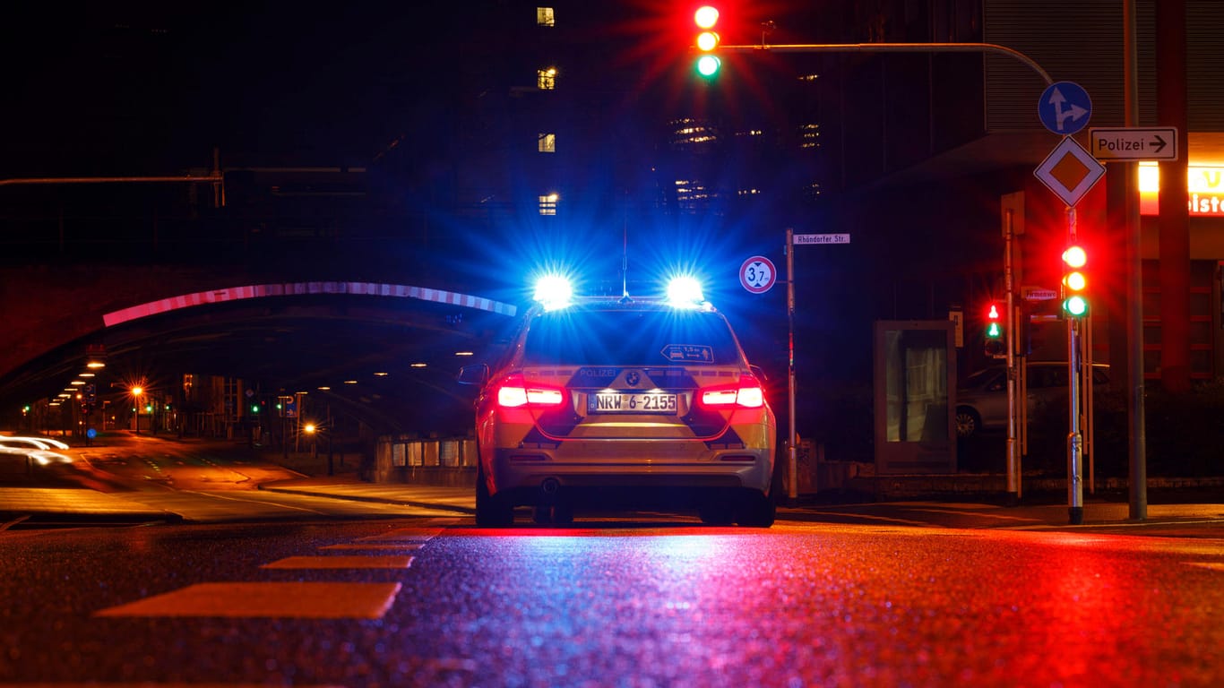 Ein Polizeiauto an einer Ampel (Symbolbild): In Köln wurde ein Mann niedergeschlagen.