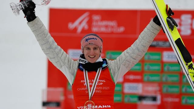 Karl Geiger feiert seinen Sieg auf dem Podium.