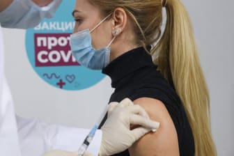 Eine Frau lässt sich in einer Shopping-Mall in Moskau mit Sputnik V impfen: Die europäische Arzneibehörde EMA prüft die Zulassung des Mittels.