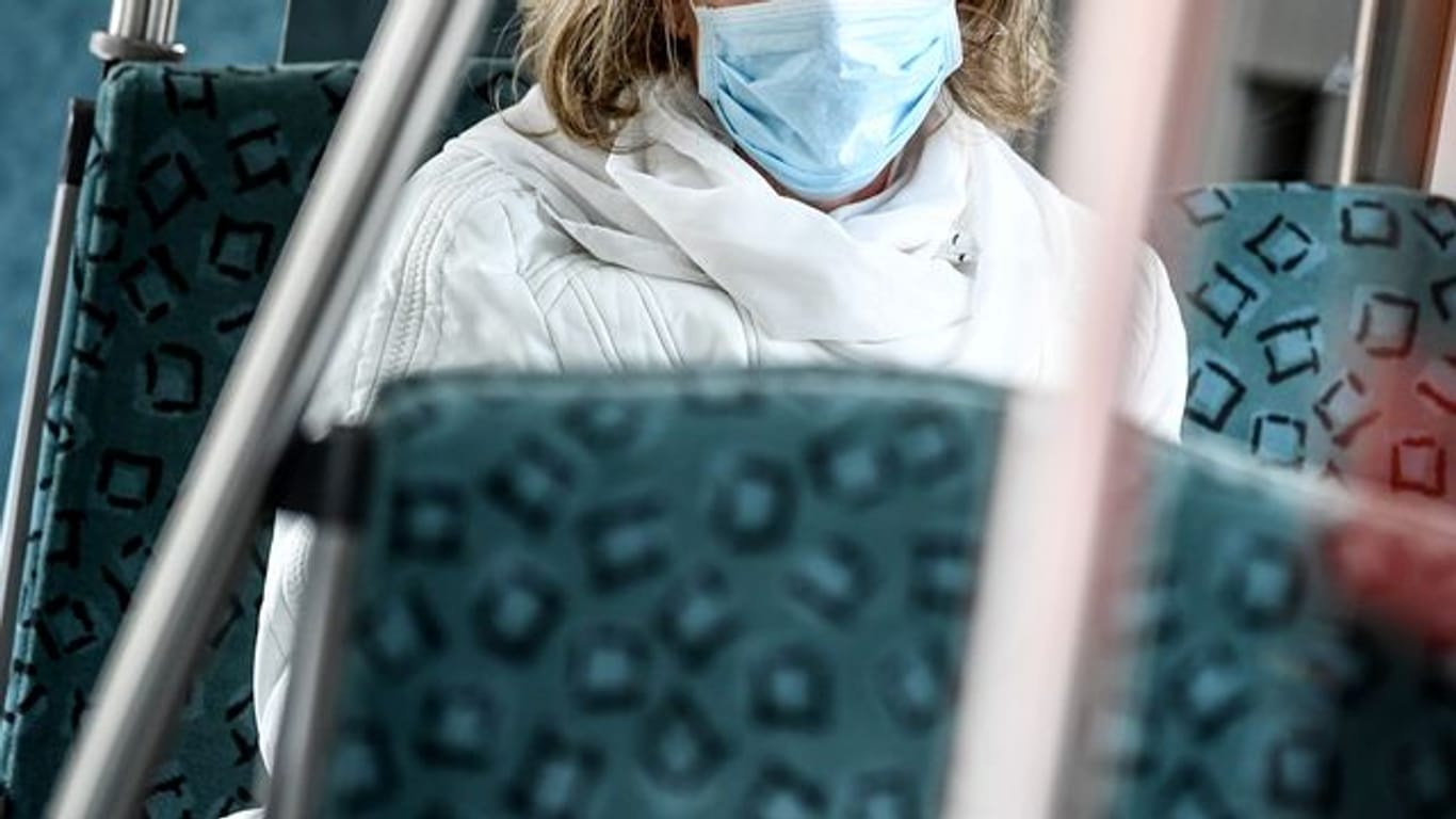 Eine Frau trägt in einer S-Bahn in Berlin einen Mundschutz.
