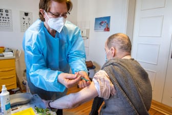 Arzthelferin impft einen Patienten (Archivbild): Auch in Hausarztpraxen soll bald gegen das Coronavirus geimpft werden.