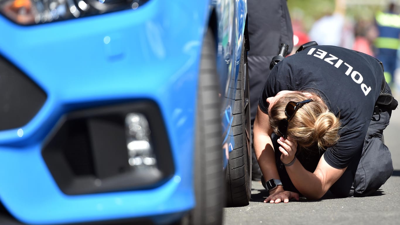 Eine Beamtin inspiziert ein Auto (Archivbild): Die Polizei in NRW bereitet sich auf den "Car-Freitag" vor.
