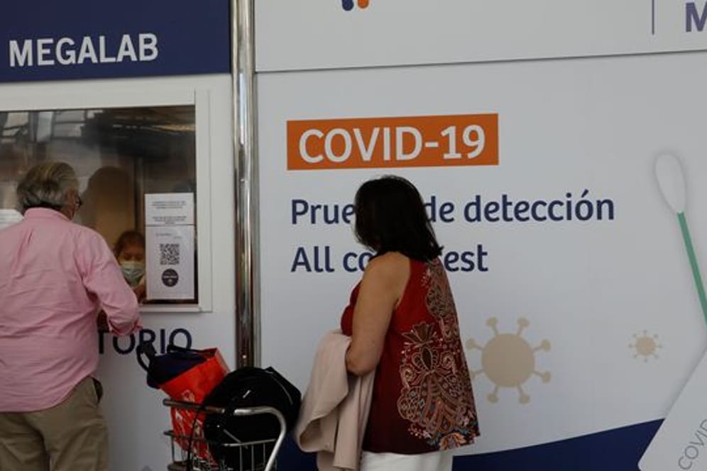 Menschen stehen vor einem Covid-19-Testzentrum auf dem Flughafen von Palma.