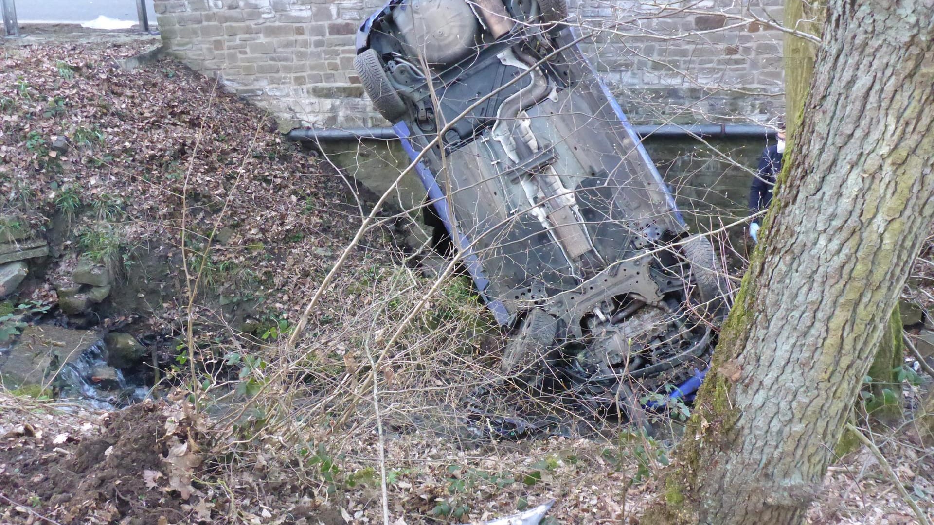 Ein Auto steht senkrecht in einem Bach: Der 18-Jährige kletterte noch selbstständig aus dem Wrack, kam aber verletzt in ein Krankenhaus. Ein Auto steht senkrecht in einem Bach: Der 18-Jährige kletterte noch selbstständig aus dem Wrack, kam aber verletzt in ein Krankenhaus.