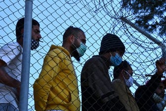 Migranten in einem Flüchtlingscamp am Hafen von Vathy auf der Insel Samos beobachten den Besuch der EU-Innenkommissarin Johansson.
