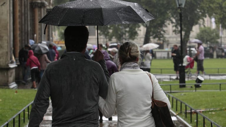 Paar im Regen: Der Mann hält mit dem rechten Arm den Schirm. (Symbolbild)