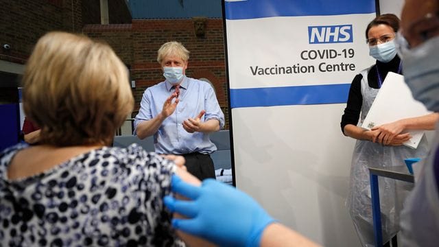 Boris Johnson applaudiert, nachdem eine Krankenschwester eine Patientin im Guy's Hospital verabreicht hat. Boris Johnson applaudiert, nachdem eine Krankenschwester eine Patientin im Guy's Hospital verabreicht hat.