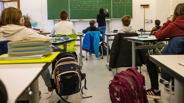 Schülerinnen und Schüler einer fünften Klasse sitzen während dem Unterricht in ihrem Klassenzimmer.