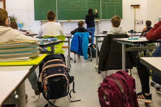 Schülerinnen und Schüler einer fünften Klasse sitzen während dem Unterricht in ihrem Klassenzimmer.