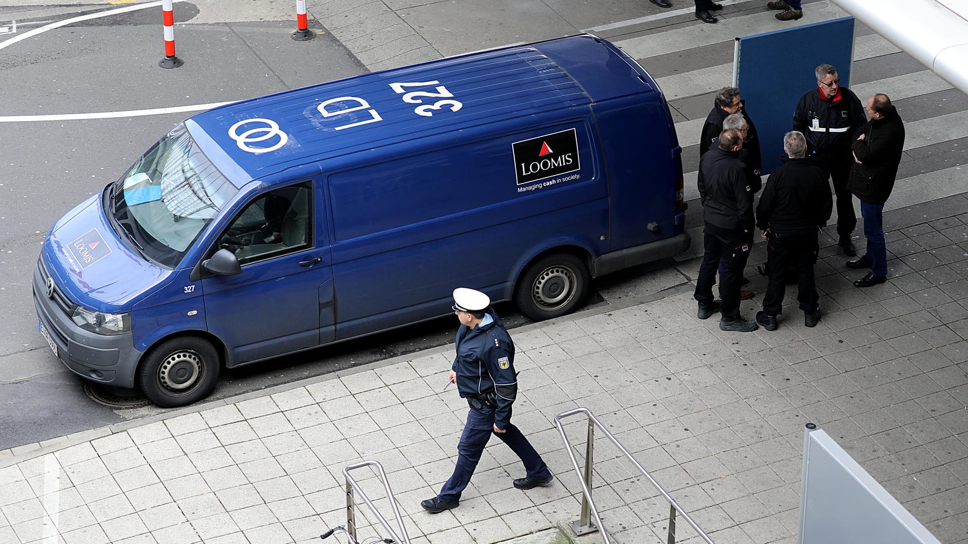 Polizisten und Mitarbeiter einer Sicherheitsfirma stehen neben einem Geldtransporter am Flughafen Köln-Bonn (Archivbild): Der Geldwagen war zuvor überfallen worden. Polizisten und Mitarbeiter einer Sicherheitsfirma stehen neben einem Geldtransporter am Flughafen Köln-Bonn (Archivbild): Der Geldwagen war zuvor überfallen worden.