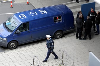 Polizisten und Mitarbeiter einer Sicherheitsfirma stehen neben einem Geldtransporter am Flughafen Köln-Bonn (Archivbild): Der Geldwagen war zuvor überfallen worden.