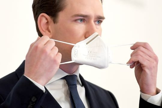 Sebastian Kurz (ÖVP), Bundeskanzler von Österreich, setzt bei einer Pressekonferenz seine Mund-Nasen-Bedeckung auf.