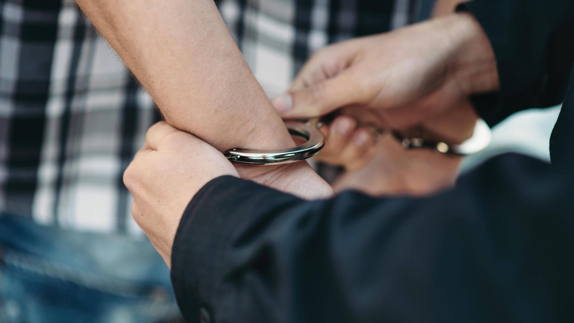 Einem Mann werden Handschellen angelegt (Symbolbild): Zwei Männer werden in Berlin verdächtigt, einen Hausbewohner erschlagen zu haben.