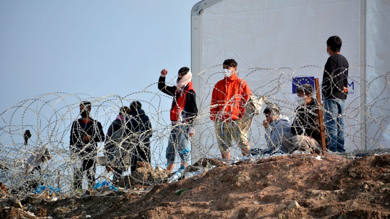 Auf der griechischen Insel Lesbos: Flüchtlinge stehen an einem Stacheldrahtzaun.