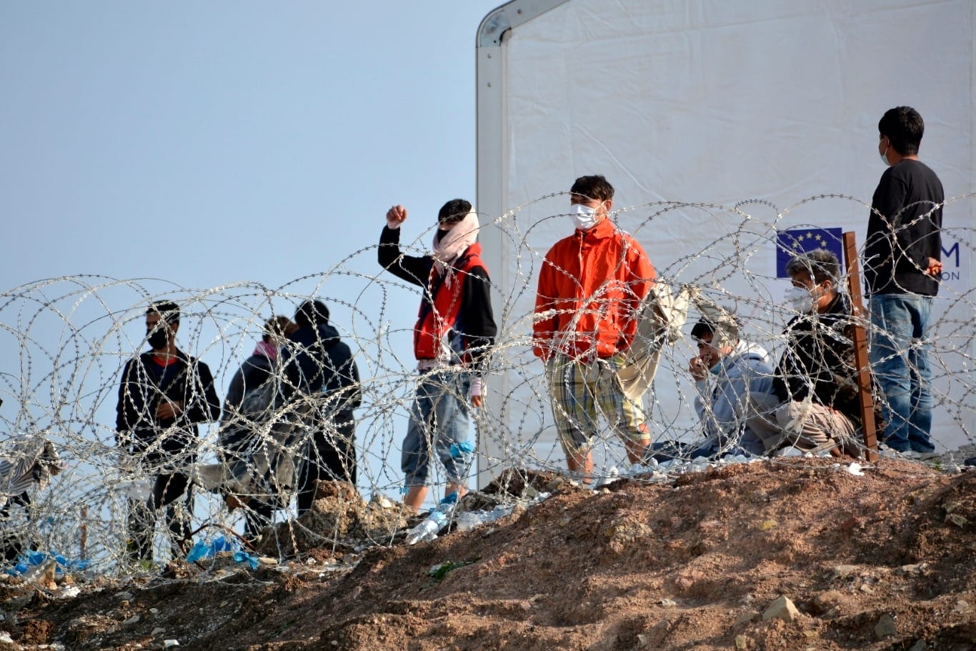 Auf der griechischen Insel Lesbos: Flüchtlinge stehen an einem Stacheldrahtzaun.