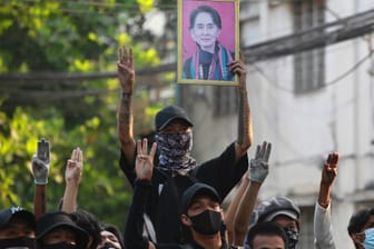 Demonstranten in Yangon halten am Donnerstag ein Bild der beliebten Politikerin Aung San Suu Kyi hoch.