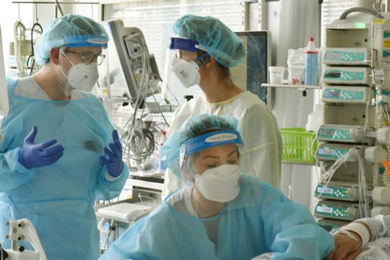 Mediziner stehen bei einem Patienten in der Covid-19-Station (Symbolbild): Die Uniklinik Leipzig muss Patienten aus Corona-Hotspots in Südsachsen aufnehmen.
