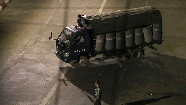 Polizisten sitzen in einem Lastwagen und fahren Patrouille in Yangon. Polizisten sitzen in einem Lastwagen und fahren Patrouille in Yangon.