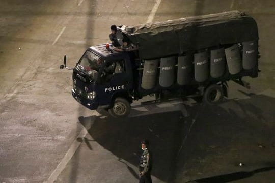 Polizisten sitzen in einem Lastwagen und fahren Patrouille in Yangon.