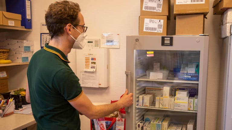 Dr. Johannes Nolte holt aus einem Kühlschrank in der Zollturm-Apotheke in Köln-Porz-Zündorf Spritzen: Bei seinen Hausbesuchen verimpft er den Impfstoff von Biontech.