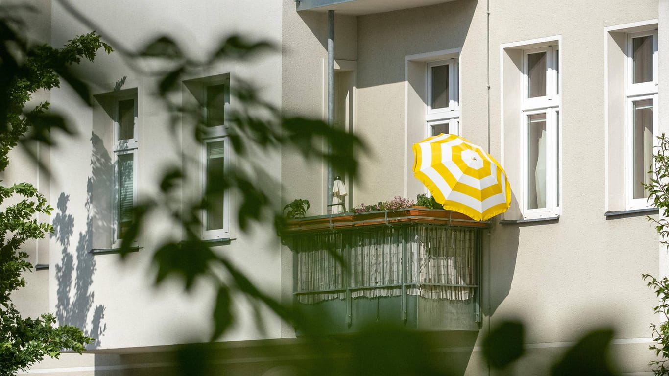 Balkon mit Sonnenschirm (Symbolbild): Berlin geht gegen illegale Ferienwohnungen vor.