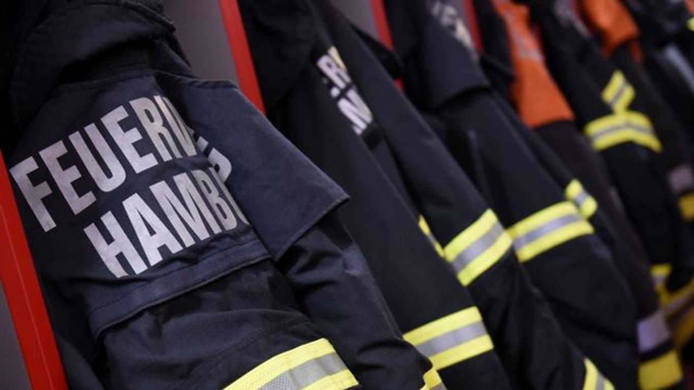 Feuerwehr-Einsatzjacken hängen in einer Feuerwache in Hamburg.