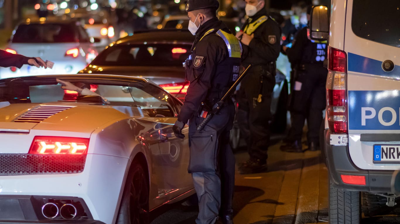 Polizisten überprüfen in Dortmund die Papiere eines Sportwagen-Fahrers: Am sogenannten "Car-Freitag" stellte die Polizei in NRW zahlreiche Verstöße fest.