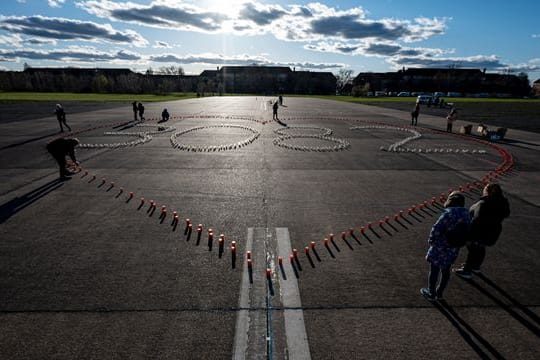 Der Kirchenkreises Tempelhof-Schöneberg gedenkt mit Kerzen in Form eines Herzen und der Zahl 3.082 an die Corona-Toten in Berlin: Die Aktion fand auf dem Tempelhofer Feld statt.