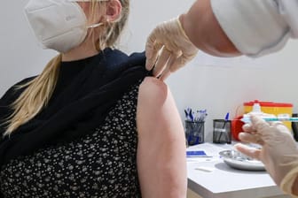 Eine Frau erhält eine Astrazeneca-Impfung in Hamburg (Archivbild). Die Deutschen sind skeptisch, ob alle bis September geimpft werden können.