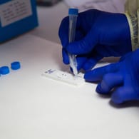 Ein Labormitarbeiter bedient einen Corona-Test (Archivbild). Das RKI hat vorläufige Infektionszahlen für Deutschland gemeldet.