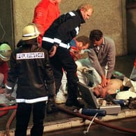 Das Bild vom 11. April 1996 zeigt Notärzte und Feuerwehrleute bei der Reanimation eines Verletzten nach dem Brand im Düsseldorfer Flughafen (Archivbild).