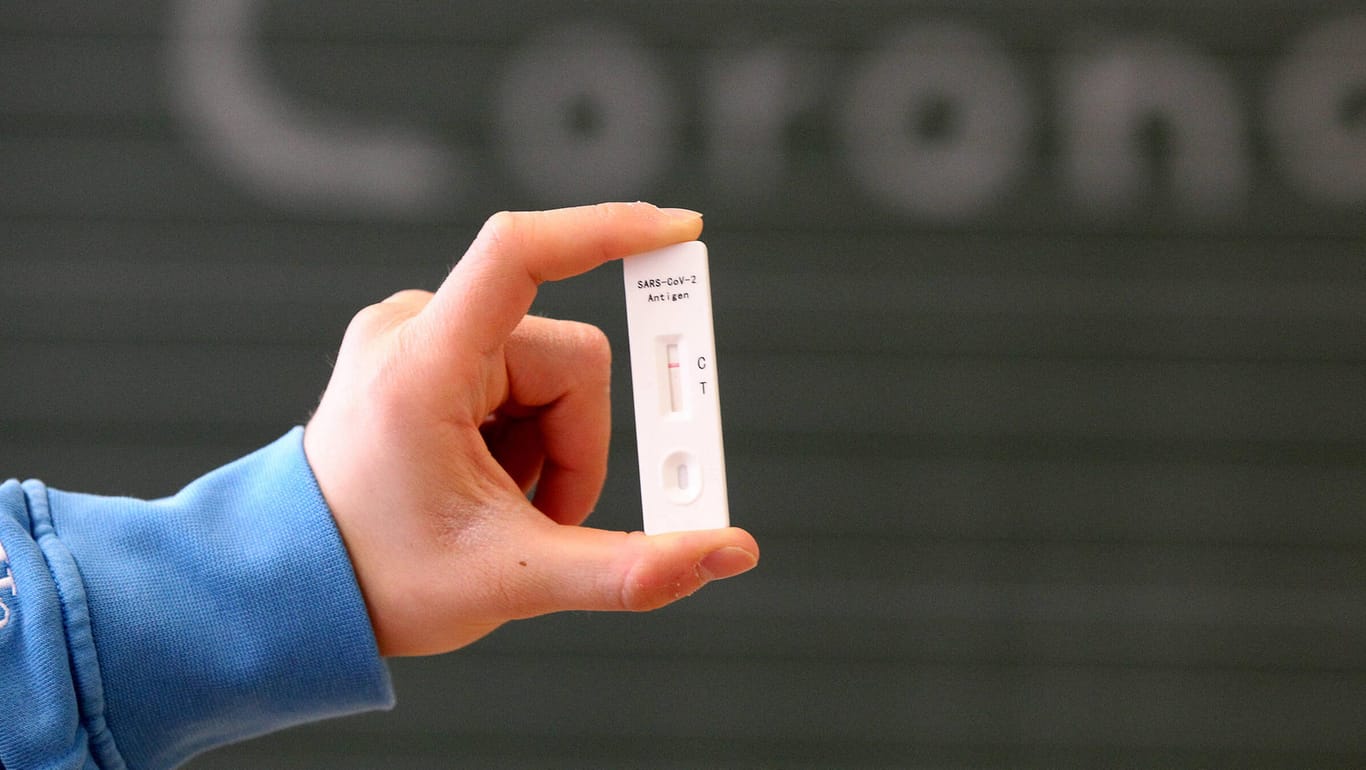 Ein Schüler hält einen Schnelltest hoch (Symbolbild): In NRW soll es an Schulen eine Testpflicht geben.