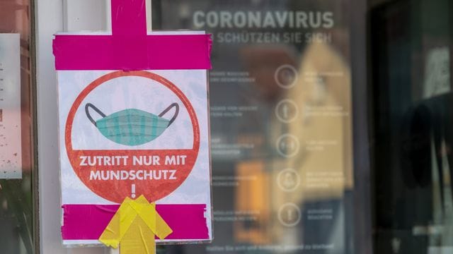 Ein Hinweisschild zeigt am Eingang eines Restaurants, dass der Zutritt nur mit Mund-Nasen-Schutz erlaubt ist. Ein Hinweisschild zeigt am Eingang eines Restaurants, dass der Zutritt nur mit Mund-Nasen-Schutz erlaubt ist.