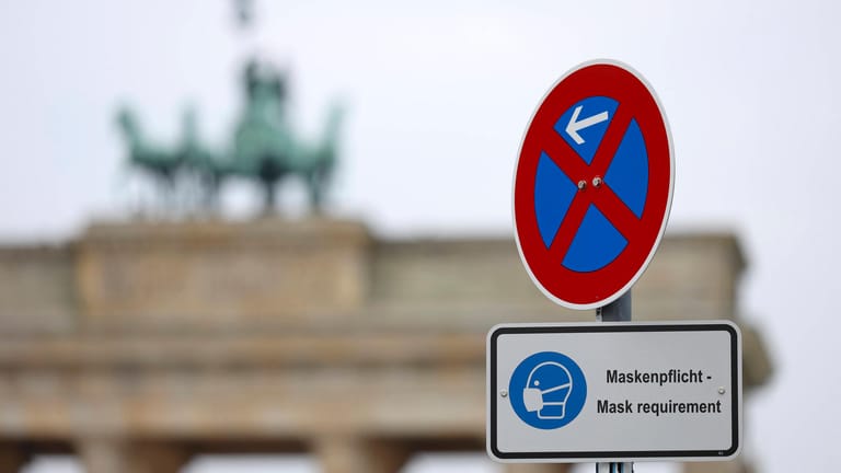 Ein Schild weist vor dem Brandenburger Tor auf die Maskenpflicht hin (Symbolbild): Berliner dürfen nach 21 Uhr keinen Besuch mehr bekommen.