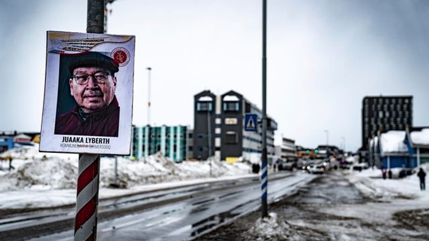 Ein Plakat eines Kandidaten der Parlamentswahl hängt an einem Laternenmast im grönländischen Nuuk.