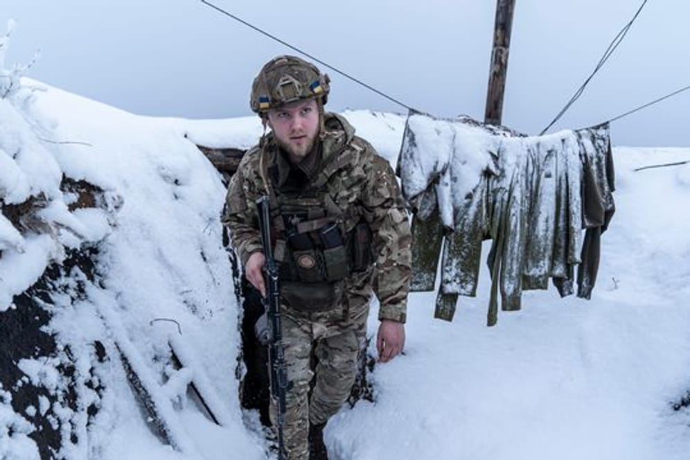 Ein ukrainischer Soldat in einem schneebedeckten Schützengraben bei Wodjane.